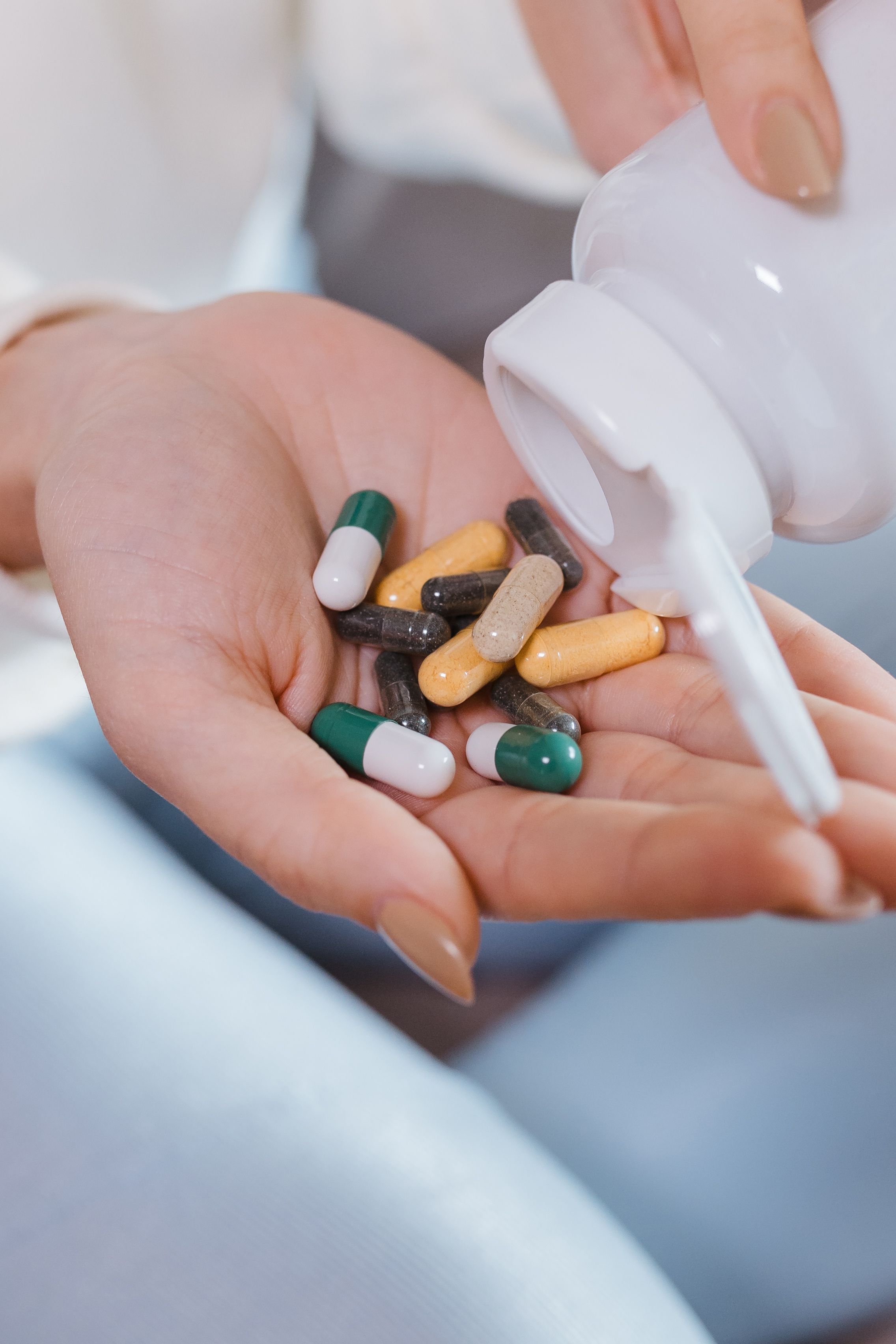 Vitamin capsules and supplement jars on a bright surface